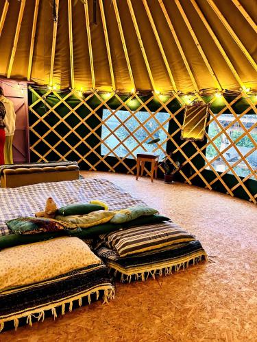 a room with a bed and a pile of blankets at A Magical Cosy Garden Yurt in Ladyʼs Odell