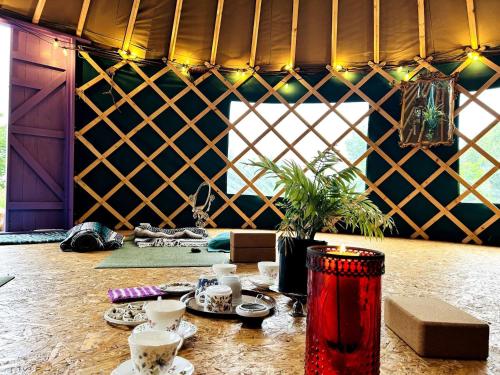a room with a table with cups and dishes on it at A Magical Cosy Garden Yurt in Ladyʼs Odell