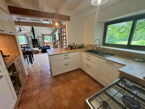 een keuken met een spoelbak en een fornuis bij Gîte du Séquoia - Paisible maison de campagne in Vallet
