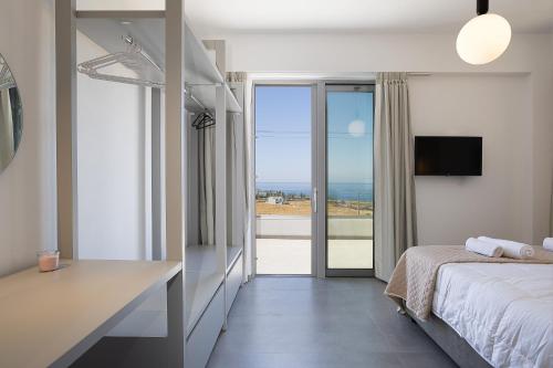 a bedroom with a bed and a view of the ocean at MiNo Mare modern Sea View Villa with Pool up to 12 in Panormos Rethymno