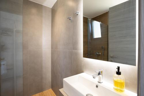 a bathroom with a sink and a shower and a mirror at MiNo Mare modern Sea View Villa with Pool up to 12 in Panormos Rethymno