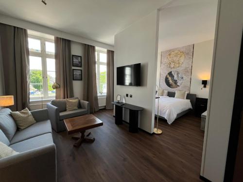 a living room with a couch and a bed at Vänerport Stadshotell i Mariestad in Mariestad