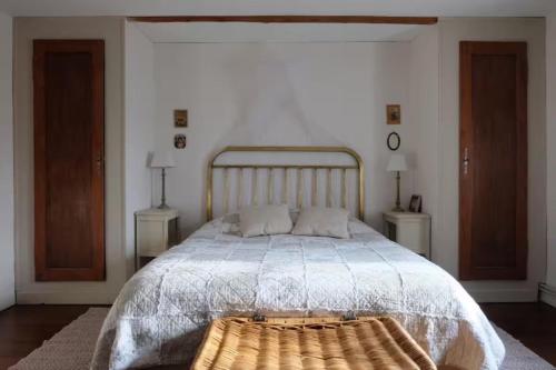 a bedroom with a large bed with a wooden headboard at Gite - Le befoigneu in Ramonchamp