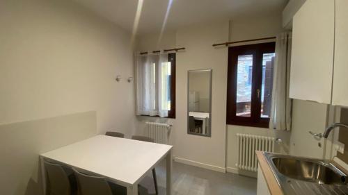a kitchen with a white table and a window at Venice Suite Ruga Bella in Venice