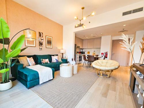 a living room with a green couch and a kitchen at Chic Yas Stay, F1, Ferrari, Sea World Yas Island in Abu Dhabi