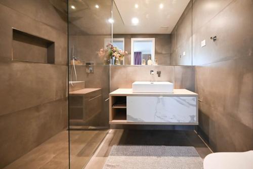 un bagno con lavandino e doccia in vetro di Chesa Blue Apartment a Rovigno (Rovinj)