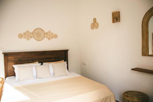 a bedroom with a bed with white pillows at Casa Sinabowewa in Ahangama
