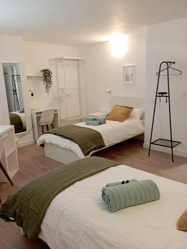 a bedroom with two beds and a desk and a ladder at Habitaciones Algodón con baño propio in Palencia
