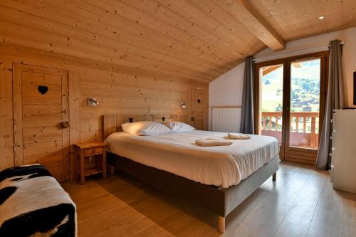 Un dormitorio con una cama en una cabaña de madera. en Chalet Anou - proche pistes de ski, en Le Chinaillon