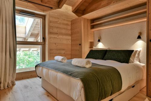 Un dormitorio con una cama grande en una habitación con ventana. en Chalet Chinaille A1, en Le Chinaillon