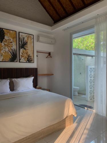een slaapkamer met een bed en een groot raam bij Udãra Hideaway Villa in Toyapakeh