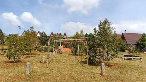 un jardin avec une structure en bois dans un champ dans l'établissement ណាវិតាយ៉ារី បឹងហ្គាឡូ Navitayary Bungalow, à Krong Saen Monourom