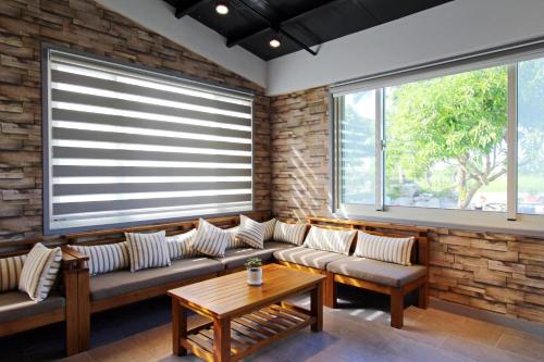 a living room with a couch and two windows at The Green Mile Field B&B in Jian