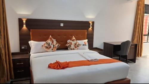 - une chambre avec un grand lit et un bureau dans l'établissement Moonshine walkers furnished apartments, à Munyu