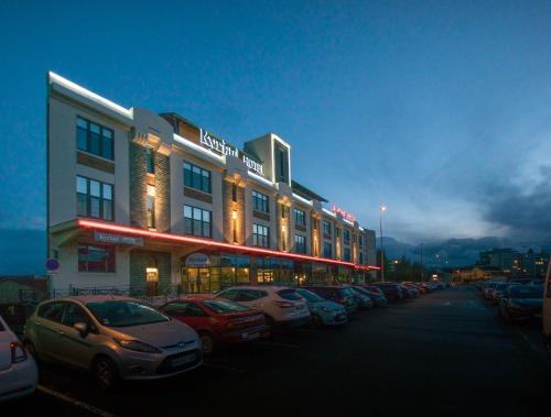 una fila de autos estacionados frente a un edificio en Kyriad Limoges Centre Gare - Atrium, en Limoges