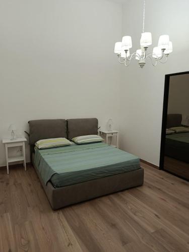 a bedroom with a bed and a chandelier at Ionian Breeze in Taranto