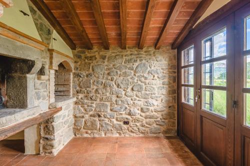 コルトーナにあるAgriturismo Podere Ponticelli - Villa con vista su Cortonaの石壁と木製のドアが特徴の客室