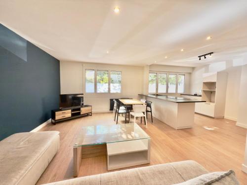 a living room with a couch and a table at T4 moderne parking Théodore Bac - DABNB in Limoges