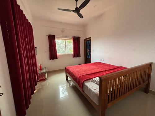 une chambre avec un lit et un ventilateur de plafond dans l'établissement Tea Haze Cottage, à Anachal