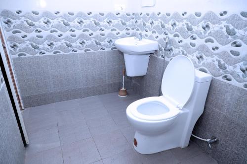 une salle de bains avec toilettes et lavabo dans l'établissement Tea Haze Cottage, à Anachal