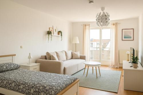 ライプツィヒにあるCity Lodge Leipzigの白いリビングルーム(ソファ、ベッド付)