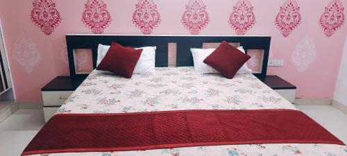Un dormitorio con una cama grande con almohadas rojas. en Kiran Home Stay, en Agra