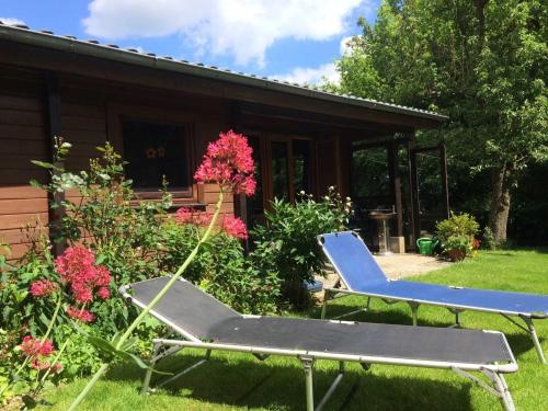 two lounge chairs in the yard in front of a house at Ferienhaus Ostsee in Steinberg