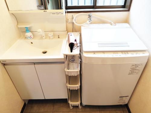 a small bathroom with a sink and a washing machine at 12名迄OK 5LDK ビーチまで徒歩3分 BBQ完備 駐車場5台White sun villa in Shirako