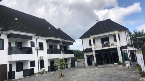 two white houses with black roofs at Vivi apartment hotel and suite in Sapele