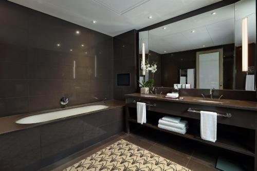 ベイルートにあるル グレイの浴槽、洗面台、鏡のあるバスルーム