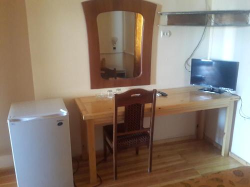 a wooden desk with a computer and a mirror at Islambek Hotel & Travel in Khiva
