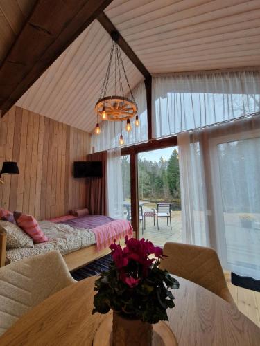 a bedroom with a bed and a table with flowers on it at Braslas čuksti in Brasla