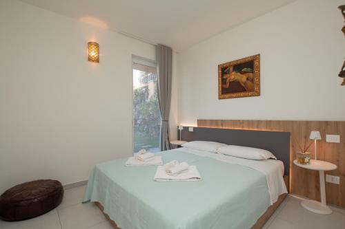 una camera da letto con un letto con due asciugamani sopra di Luce Di Mare ad Alassio