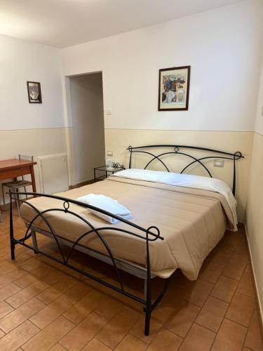 ein großes Bett in einem Zimmer mit einem Tisch in der Unterkunft Assisi, Acutis apartments in Assisi