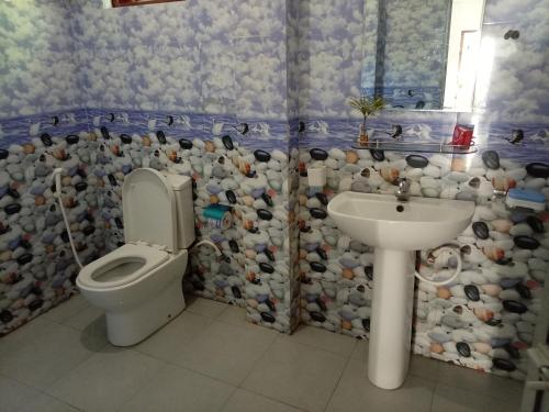 a bathroom with a toilet and a sink at White Shell in Tangalle