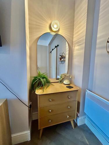 a bathroom with a wooden dresser with a mirror at 1Bd Apt City Centre Contractor Friendly in Wolverhampton