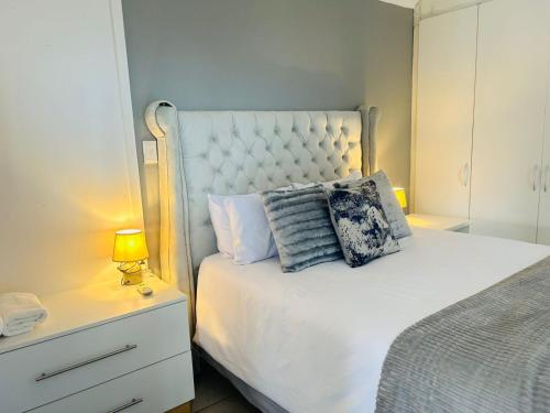 a bedroom with a white bed with a pillow on it at Richards Bay Serenity Retreat Apartments in Richards Bay