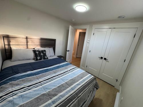 ein Schlafzimmer mit einem großen Bett und einem weißen Schrank in der Unterkunft Cozy & Stylish Retreat with Modern Comforts in Moncton