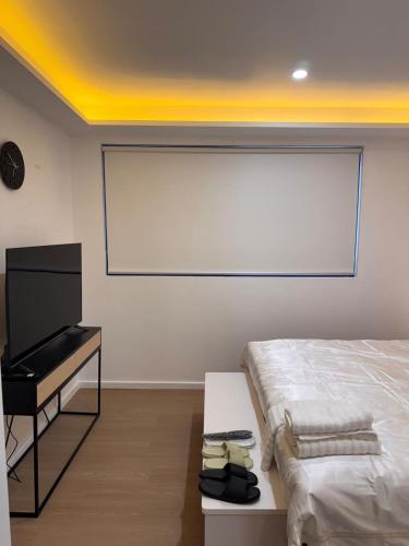Cozy Retreat close to Monash Uni and Chadstone SS في Oakleigh South: غرفة نوم بها سرير ومكتب وتلفزيون