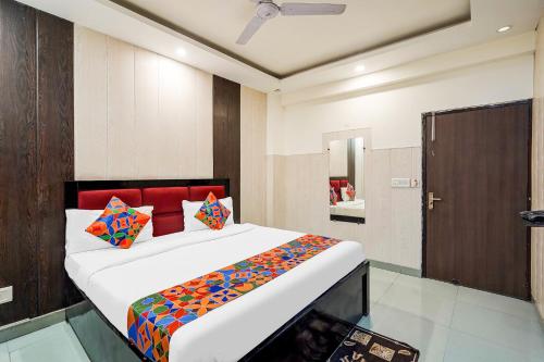 Un dormitorio con una cama grande con almohadas de colores. en FabHotel Novis House, en Noida