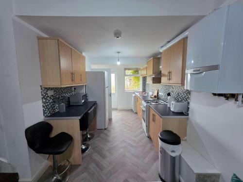 a kitchen with wooden cabinets and a white refrigerator at Inviting 3-Bed Home in Worksop with Street Parking in Creswell