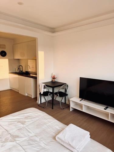 MetaWise Cozy Retreat close to Monash Uni and Chadstone U3 في Oakleigh South: غرفة معيشة مع تلفزيون بشاشة مسطحة وطاولة