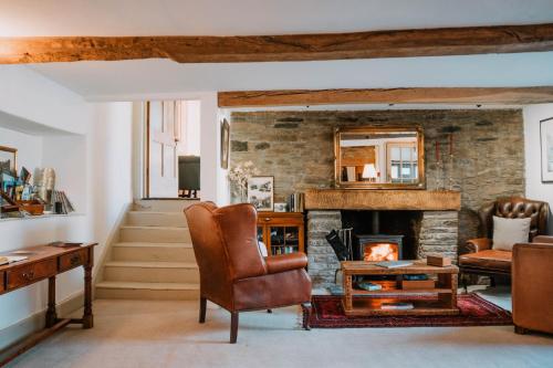 a living room with a fireplace and a chair at Three Cocks Hotel in Brecon