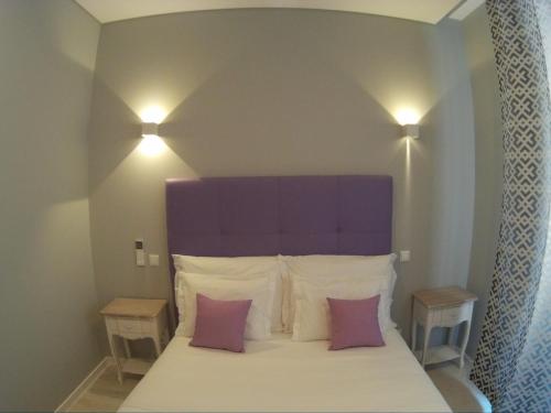 a bedroom with a bed with a purple headboard and pillows at Pensao Estacao Central in Lisbon