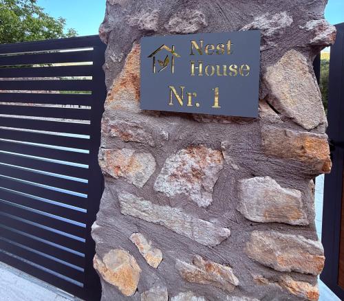 a sign on the side of a stone wall at Nest House in Dubova