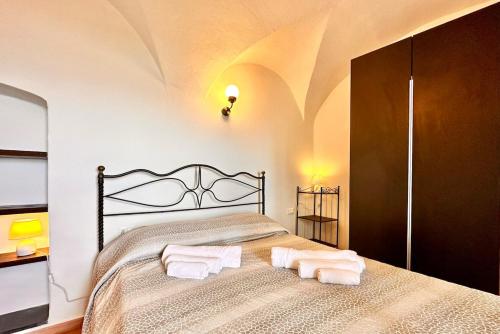 ein Schlafzimmer mit einem Bett, auf dem zwei Handtücher liegen in der Unterkunft Dimora Concept - Casa Saracena - Sea View, Terrace and Free Parking in Ranzi