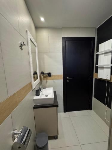 a bathroom with a sink and a black door at Apartmani Glamur Kopaonik in Kopaonik