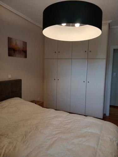 a bedroom with a bed and a large light at Stylish Luxury 3 Bd Penthouse in Drosia Center in Drosia