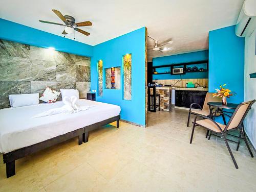 Un dormitorio con paredes azules y una cama y una mesa. en Romantic Escape I 500m Award-Winning Beach I Memory Foam King Bed I AC Kitchen WiFi 5B, en Playa del Carmen
