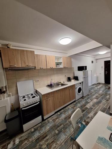 a large kitchen with a stove and a microwave at Petit Blue in Dudu